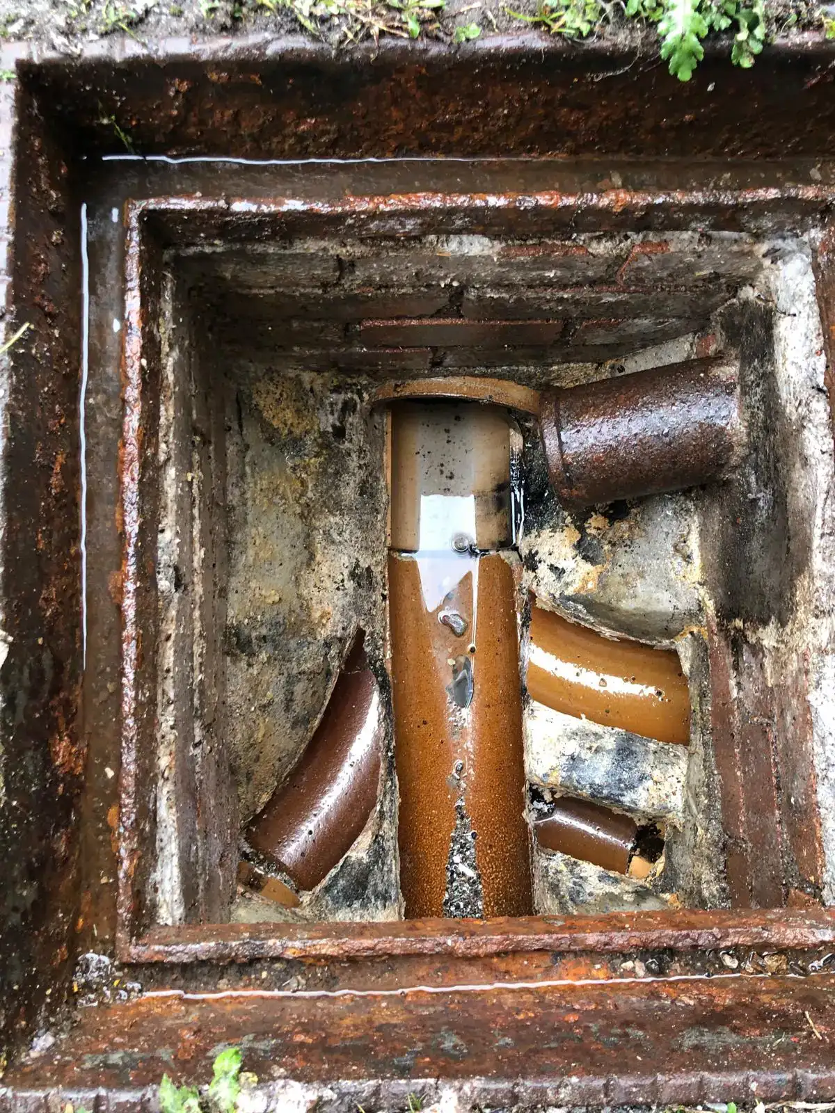 View inside manhole showing damaged clay pipes in Cornwall.